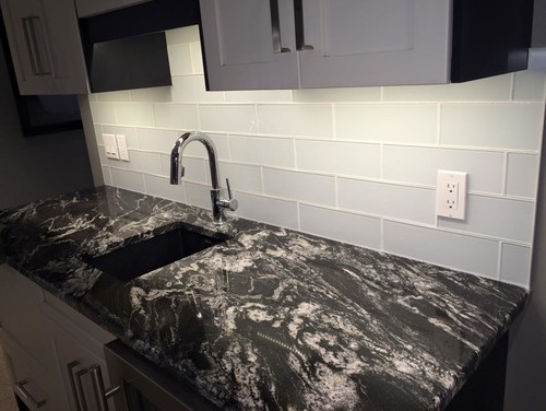 Titanium Granite With Morning Mist Glass Subway Tile and White Cabinets